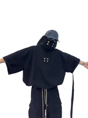 Oversized black grommet tee front view with dropped shoulders, wide sleeves, metal chest eyelets and utility side strap