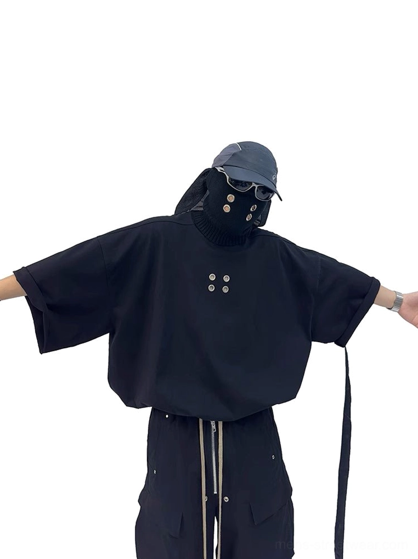 Oversized black grommet tee front view with dropped shoulders, wide sleeves, metal chest eyelets and utility side strap