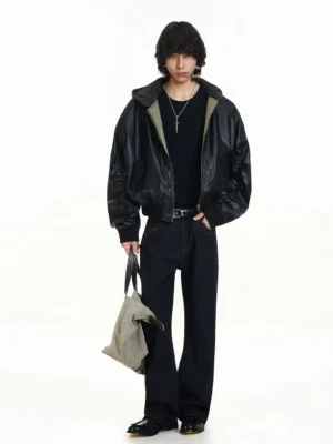 Oversized black hooded leather bomber jacket styled with dark denim and a canvas tote bag in a full-body Korean streetwear outfit