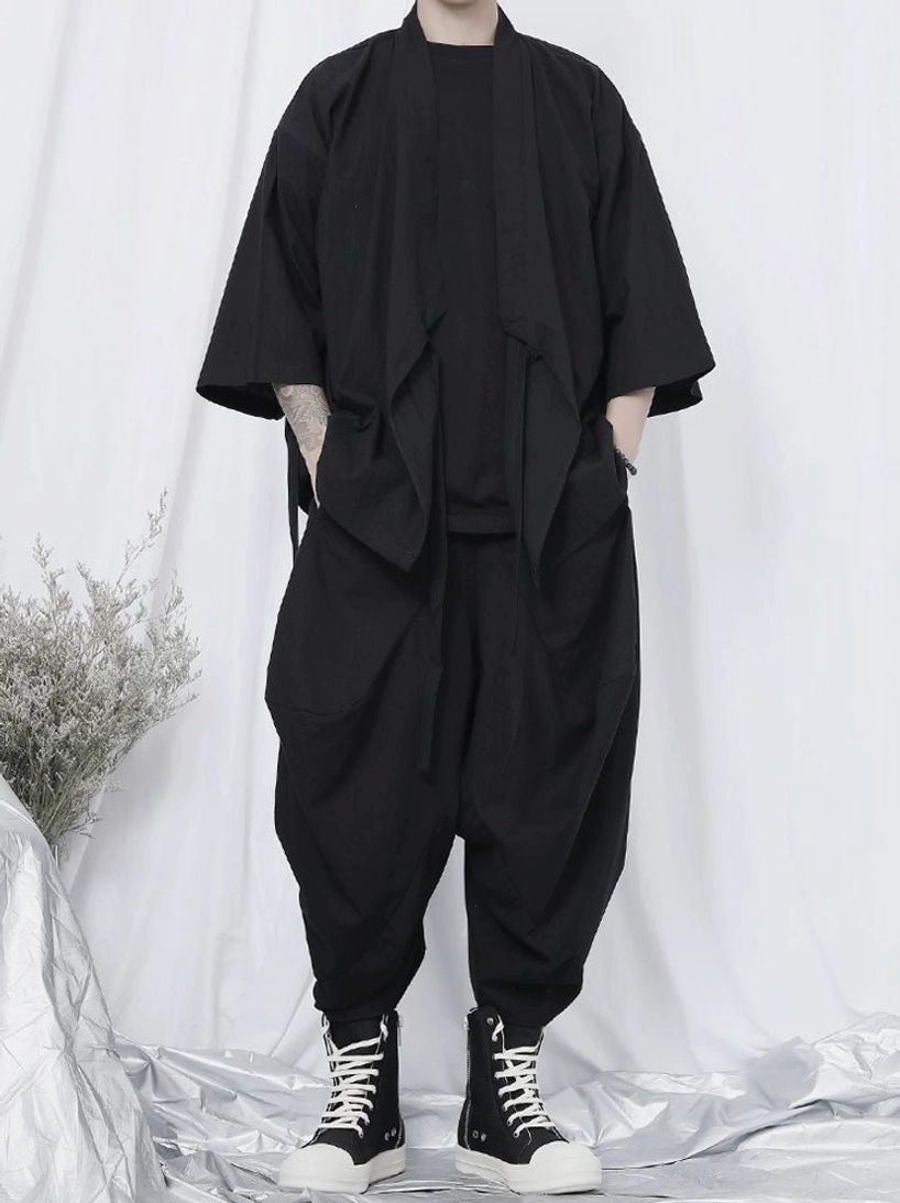 Oversized black kimono shirt with side decorative straps styled with cropped harem pants and high-top sneakers in Korean streetwear fashion
