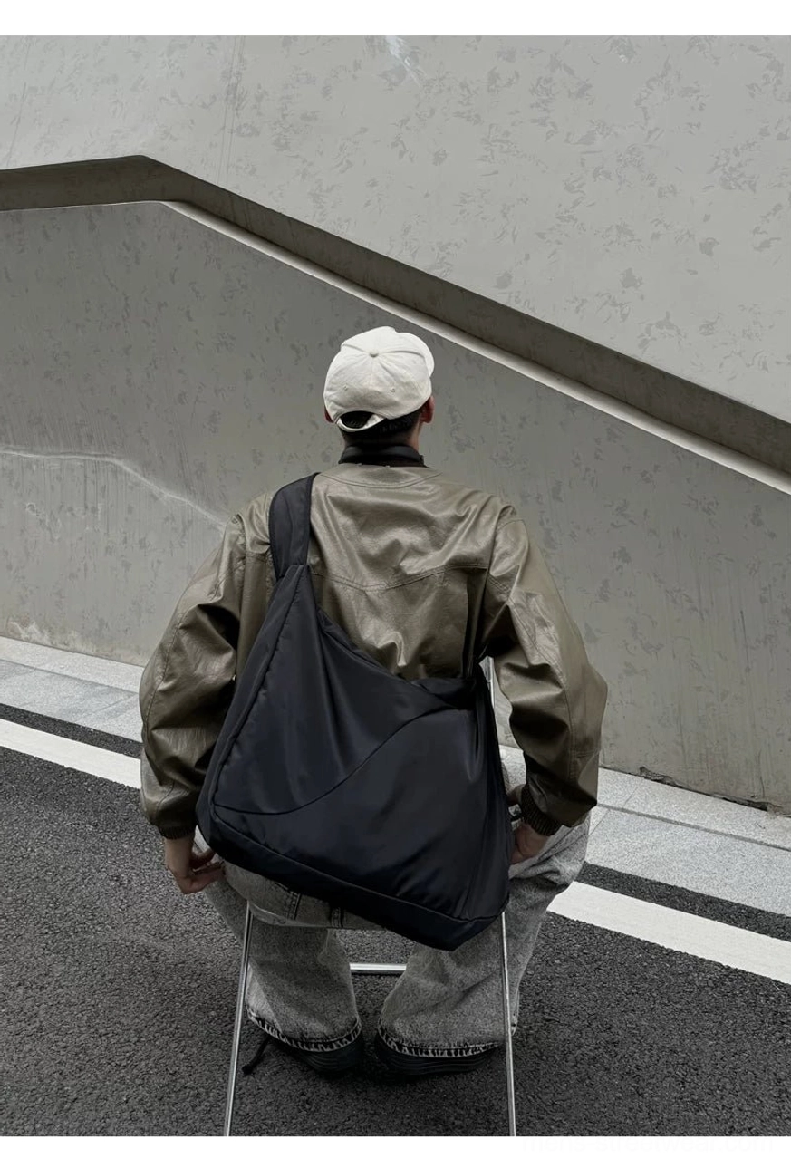 Oversized black city sling bag rear view showing smooth matte nylon fabric and clean durable stitching