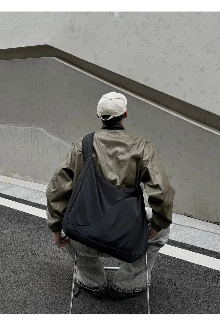 Minimalist black nylon oversized sling bag rear side view with relaxed curved hobo silhouette