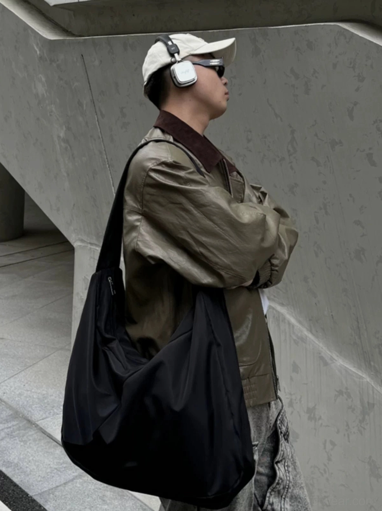 Side profile of oversized black nylon Korean streetwear sling bag with wide single shoulder strap