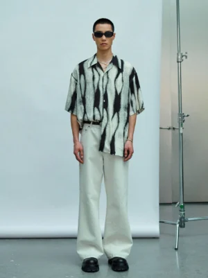 Front view of oversized black and off white tie dye color block resort shirt with dropped shoulders and wide leg streetwear styling