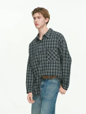 Black oversized plaid button-up shirt with drop shoulders styled with blue jeans in a three-quarter front streetwear view