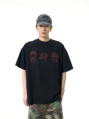 Front full body view of an oversized black punk graphic tee with maroon distressed print styled with camo cargo pants and a washed denim cap