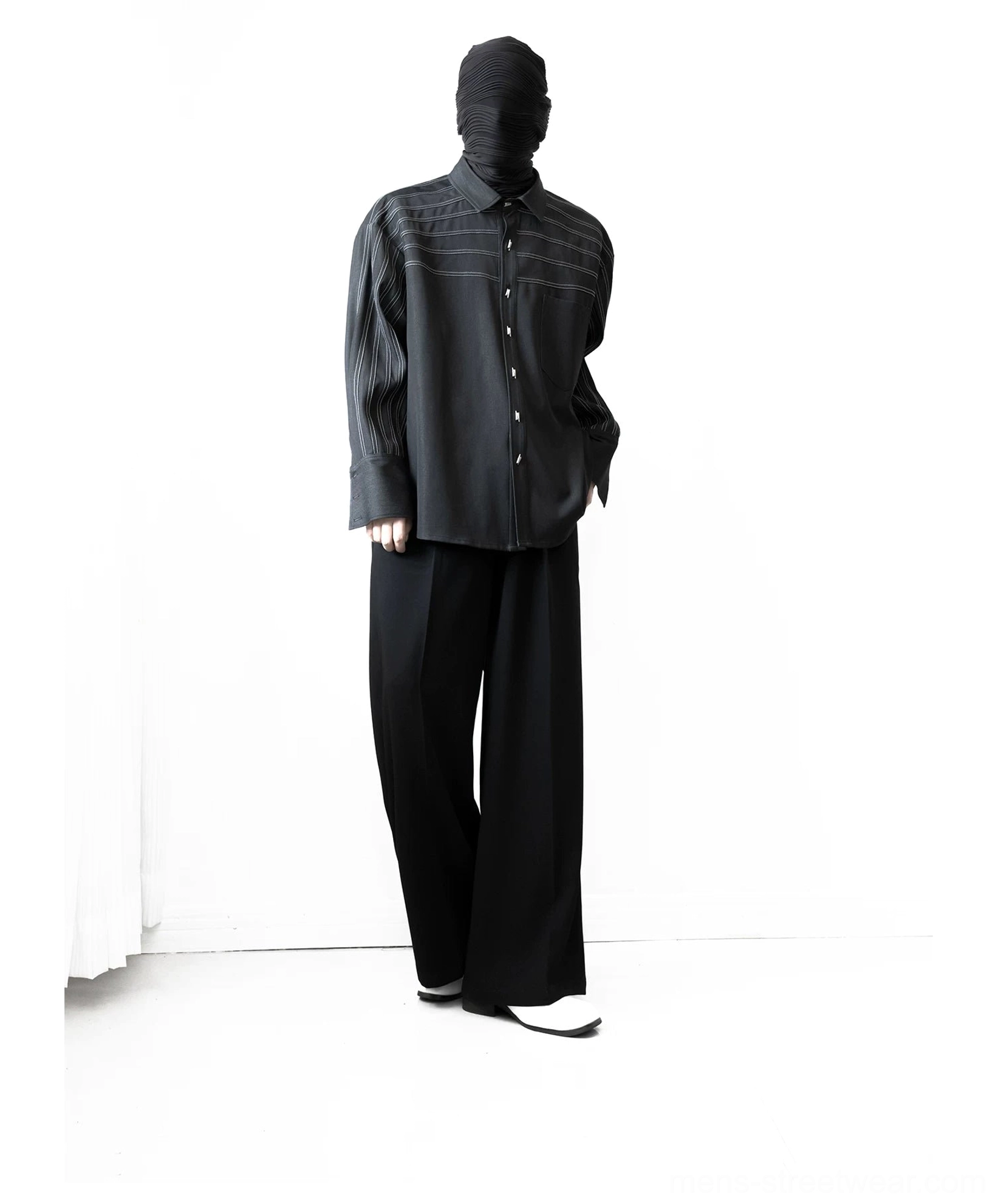 Side-front view showing the length and relaxed oversized silhouette of a black contrast stripe stitch streetwear shirt