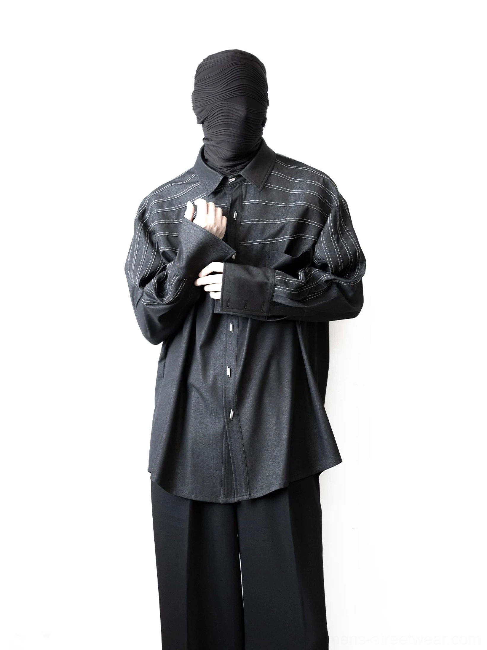 Model wearing a relaxed oversized black long-sleeve shirt with rail-inspired chest stripes, button front, and pleated sleeves
