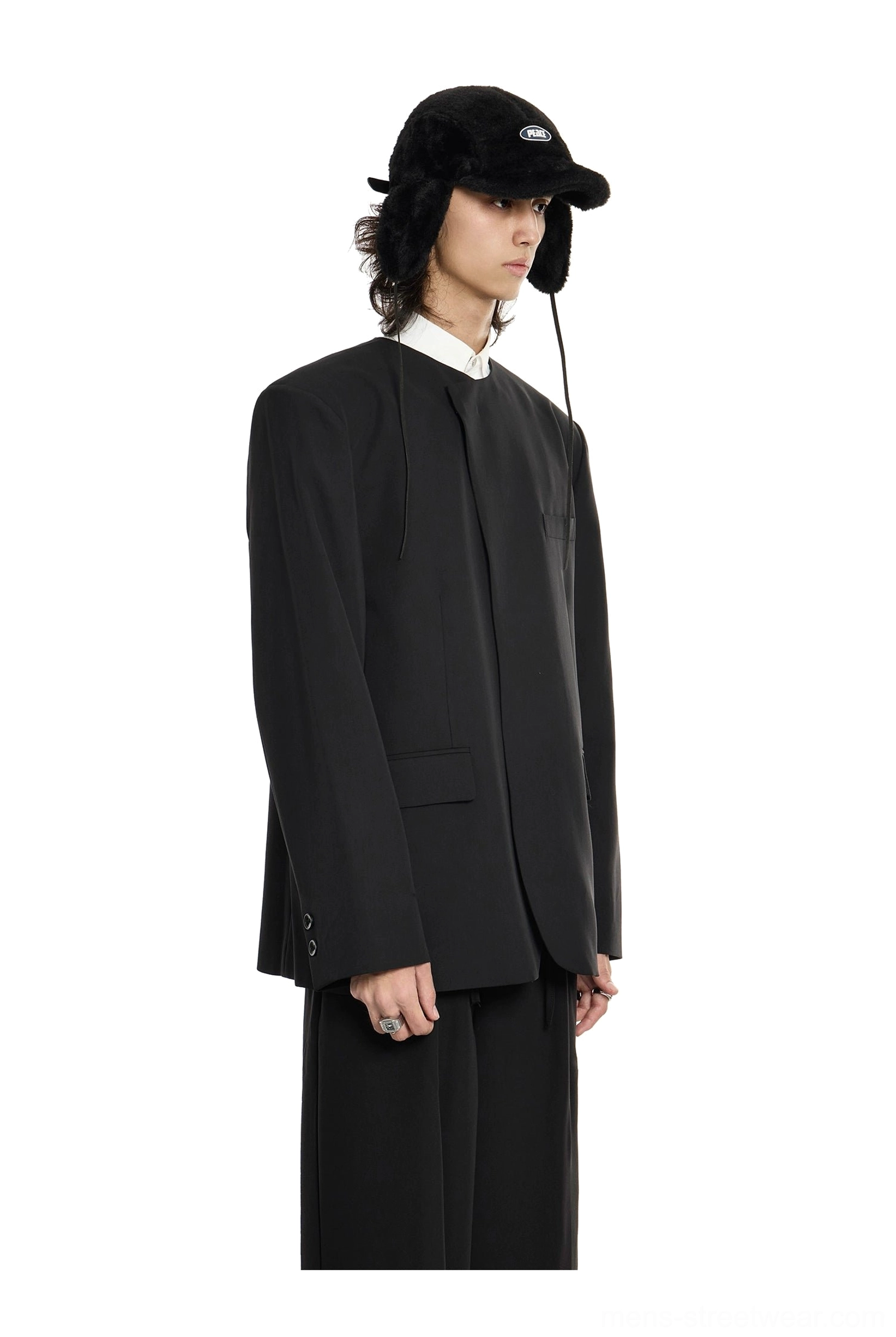 Oversized black structured blazer with concealed closure, flap pockets, and long tailored sleeves