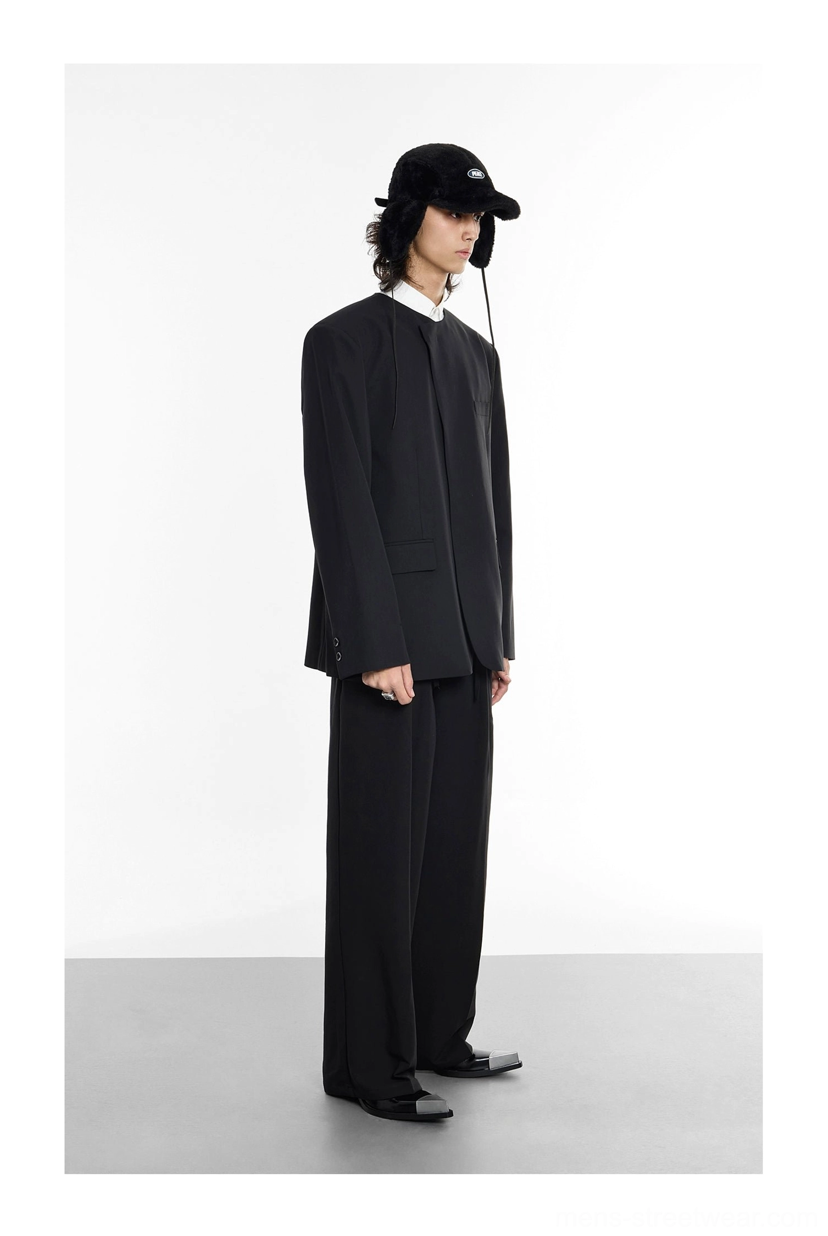 Side profile of oversized black tailored blazer showing relaxed longline structured silhouette