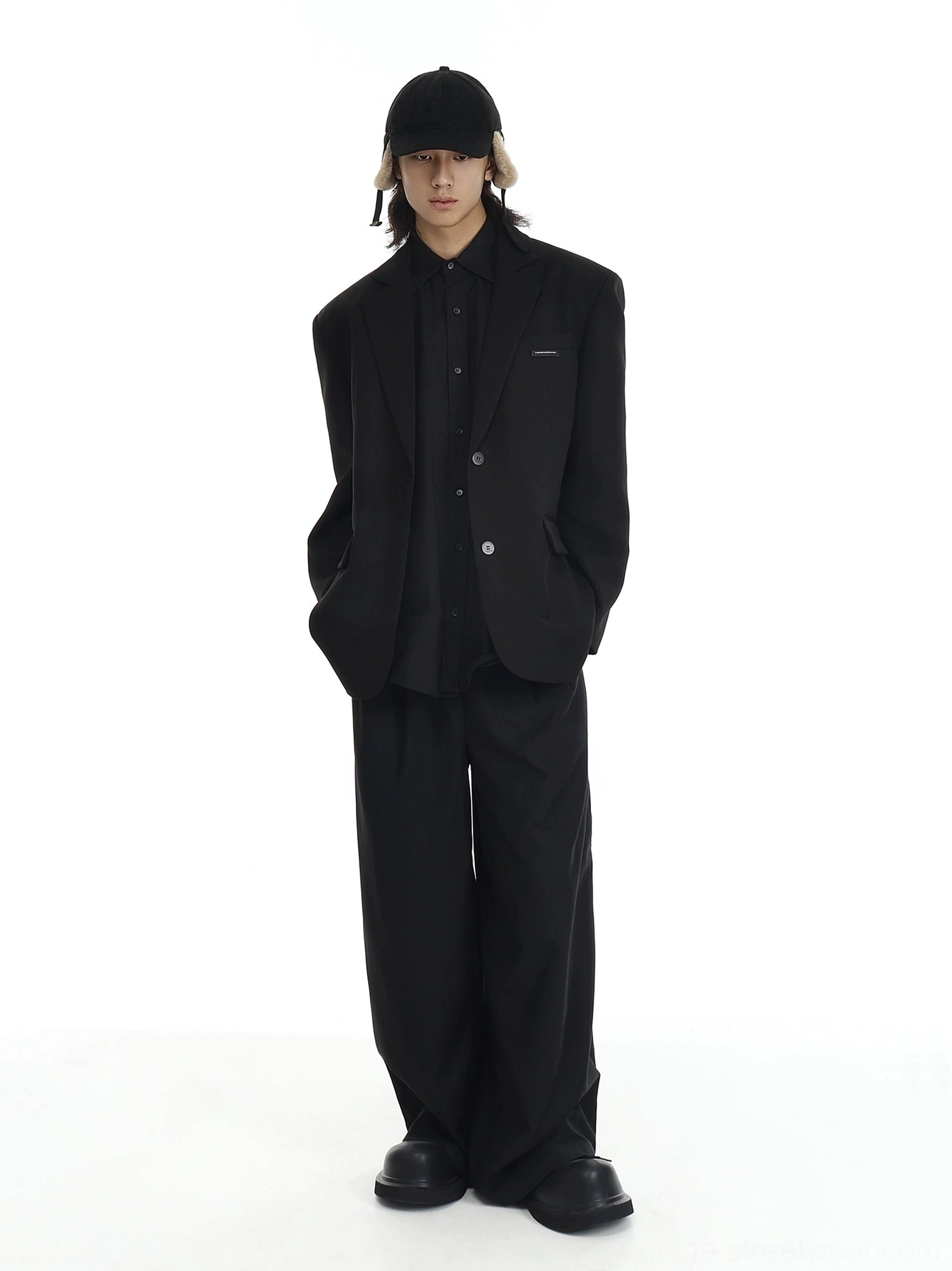 Black oversized two-button blazer styled with matching wide-leg trousers in a clean minimalist streetwear outfit