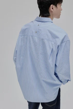 Back view of an oversized blue striped long sleeve shirt showing decorative back yoke details and drop shoulders