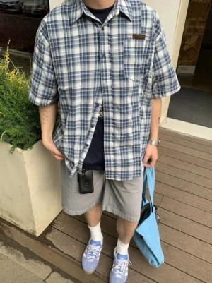 Close-up of oversized blue white plaid short sleeve streetwear shirt with button front and chest patch pocket