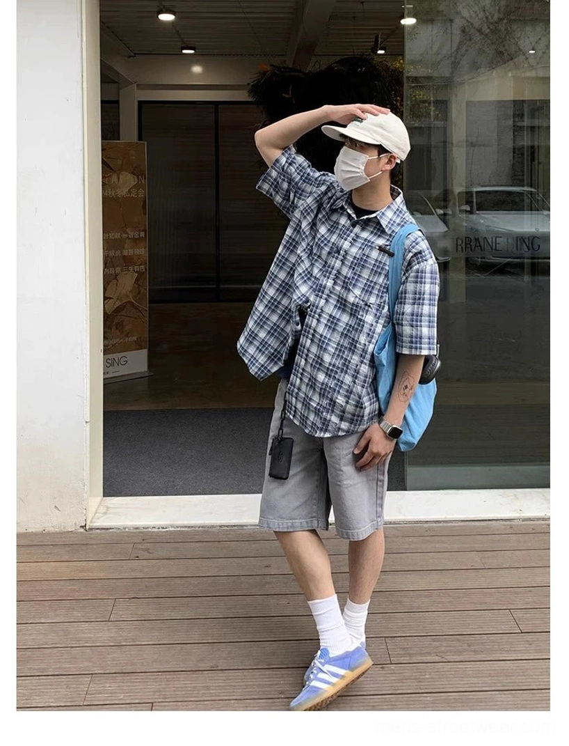 Low angle streetwear look featuring oversized blue and white plaid short sleeve shirt with casual accessories