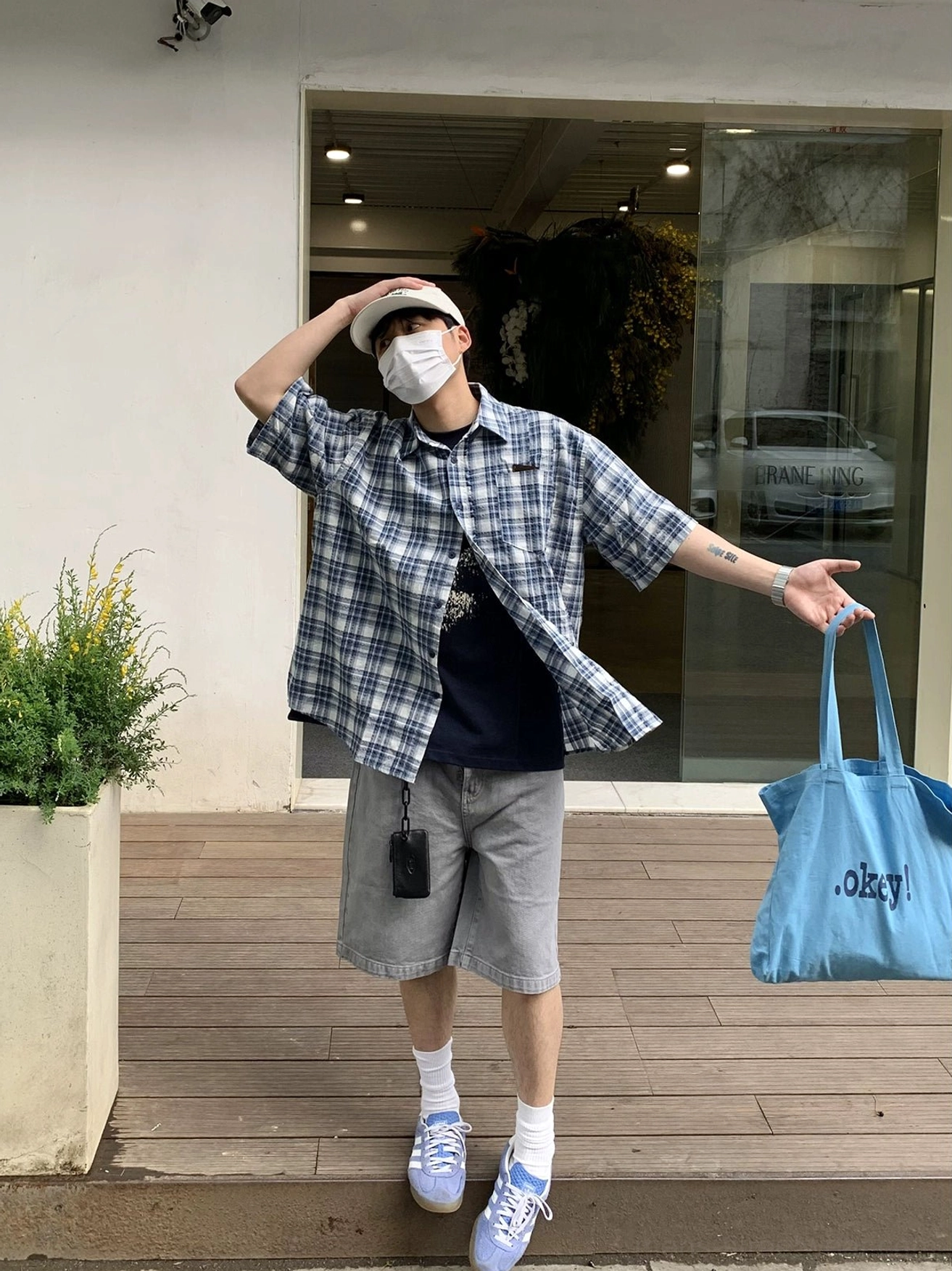 Full body outdoor styling of oversized blue and white plaid short sleeve Korean streetwear shirt