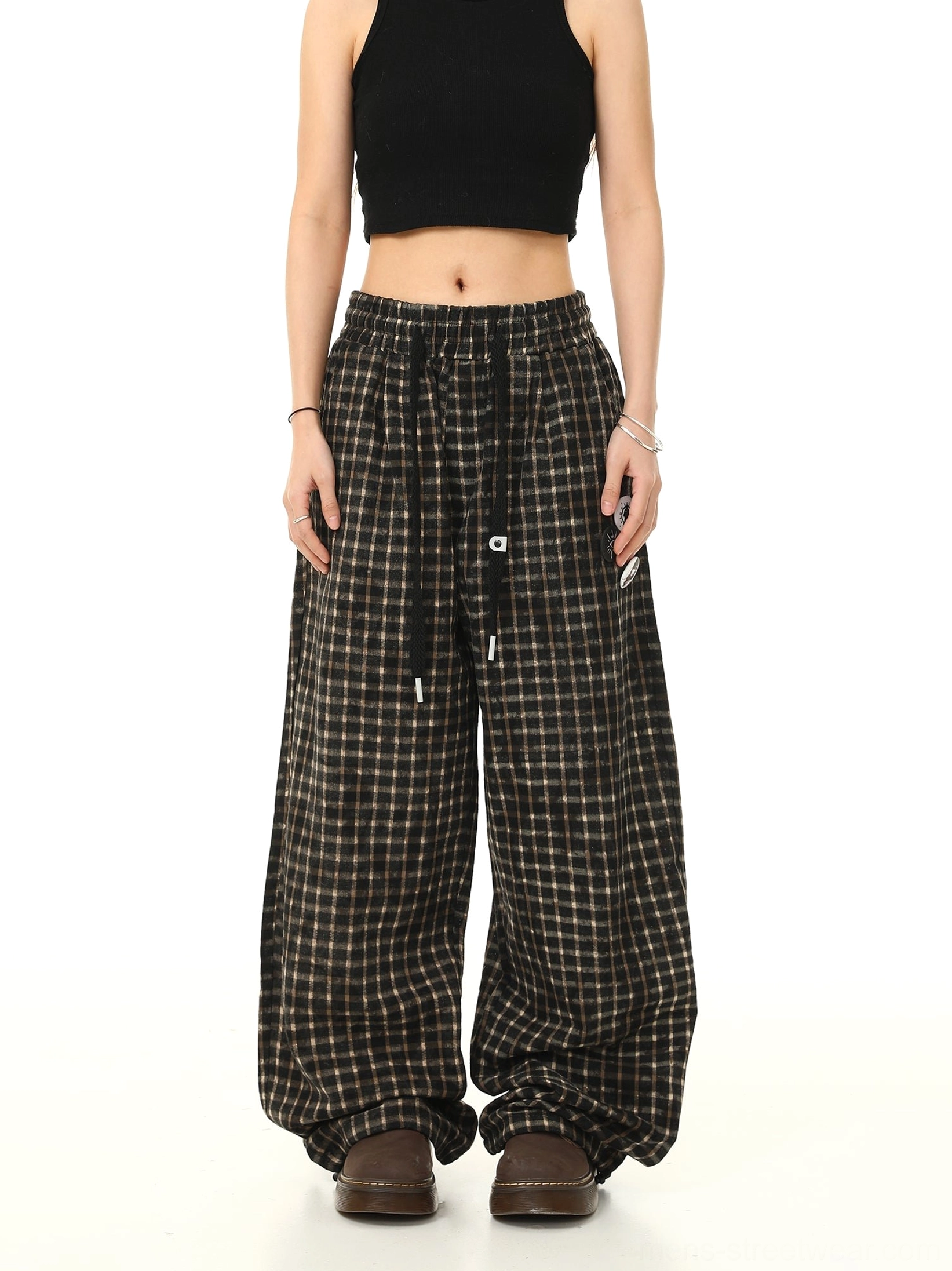 Straight front view of oversized brown black check wide leg pants with relaxed streetwear silhouette and tidy waistband