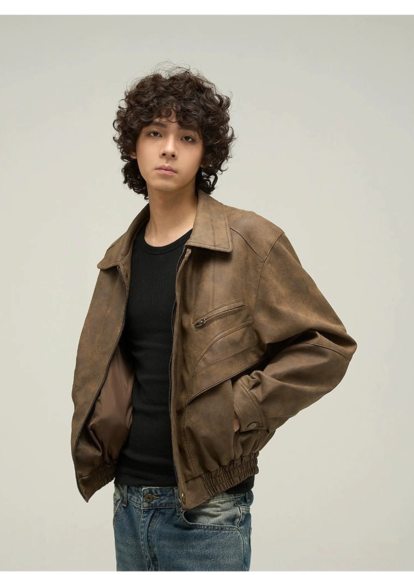 Front view of an oversized brown faux leather jacket worn partially unzipped over a black tee with exposed inner lining