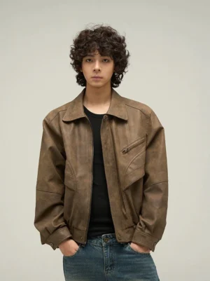 Front close-up of an oversized brown faux leather jacket with vintage distressed finish, spread collar, chest zip pocket, and Korean streetwear styling