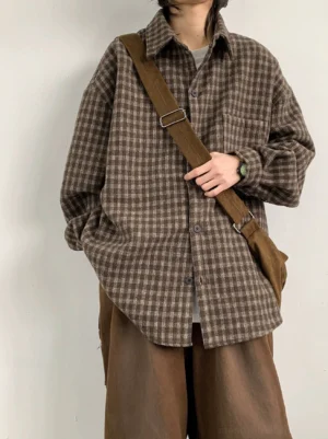 Front full-body view of an oversized brown plaid flannel shirt with drop shoulders chest pocket curved hem and wide-leg streetwear styling