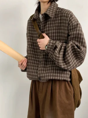 Three-quarter view of a thick brown plaid flannel overshirt with relaxed oversized fit curved hem and casual crossbody styling