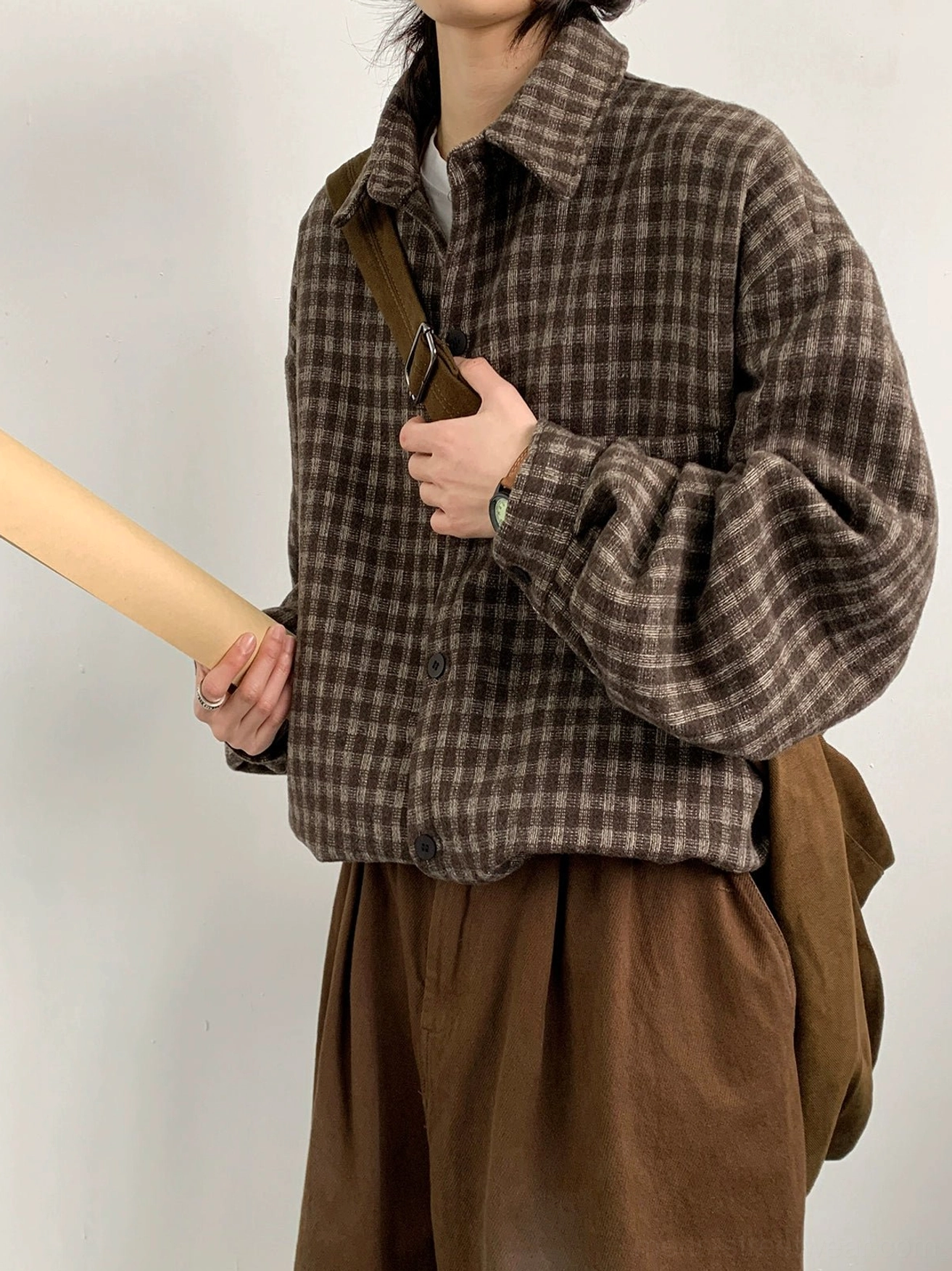 Three-quarter view of a thick brown plaid flannel overshirt with relaxed oversized fit curved hem and casual crossbody styling
