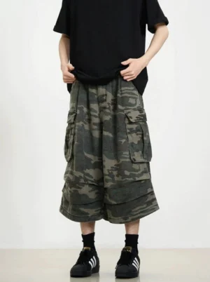 Front full-body view of oversized camouflage cargo shorts featuring wide cropped legs, utility pockets, and relaxed Korean streetwear styling