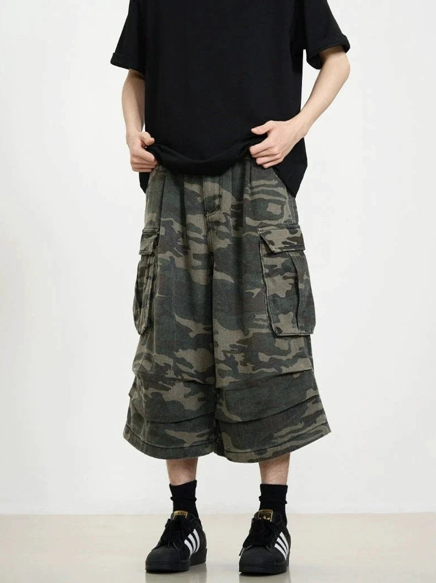 Front full-body view of oversized camouflage cargo shorts featuring wide cropped legs, utility pockets, and relaxed Korean streetwear styling