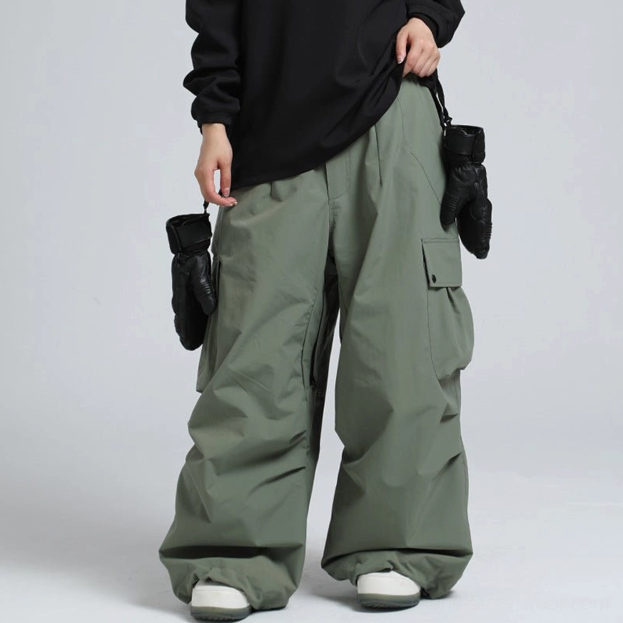 Sage green military-inspired cargo snow pants with oversized wide legs and outdoor utility styling