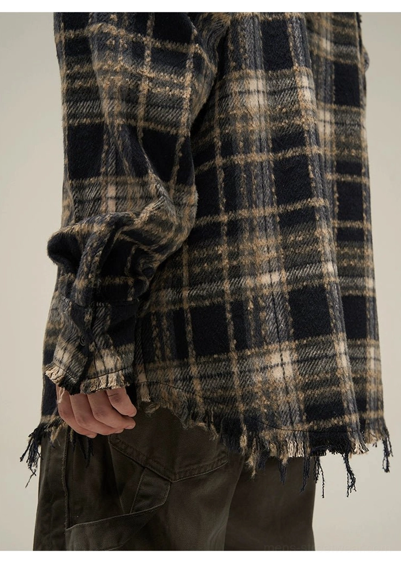 Close-up of distressed frayed hem and cuff on oversized dark plaid flannel hooded shirt