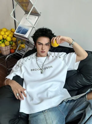 White oversized chain-lace shoulder graphic T-shirt styled with baggy jeans and silver jewelry in a Korean streetwear look