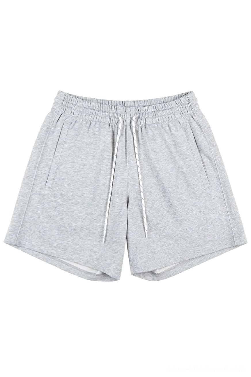 Heather gray oversized cotton sweat shorts with elastic drawstring waistband and side pockets on a white background