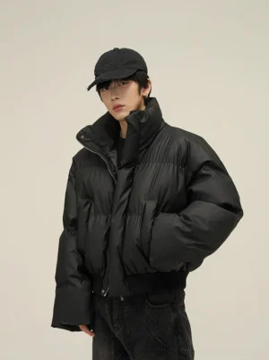 Black oversized cropped matte puffer jacket with stand collar styled with black denim and baseball cap