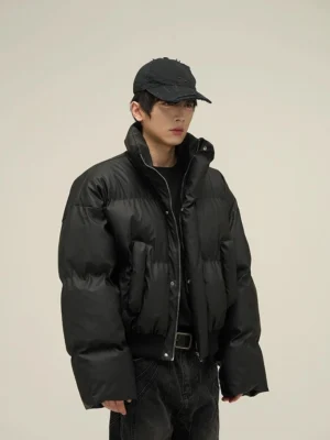 Side view of black oversized cropped puffer jacket with high collar ribbed hem and front pockets