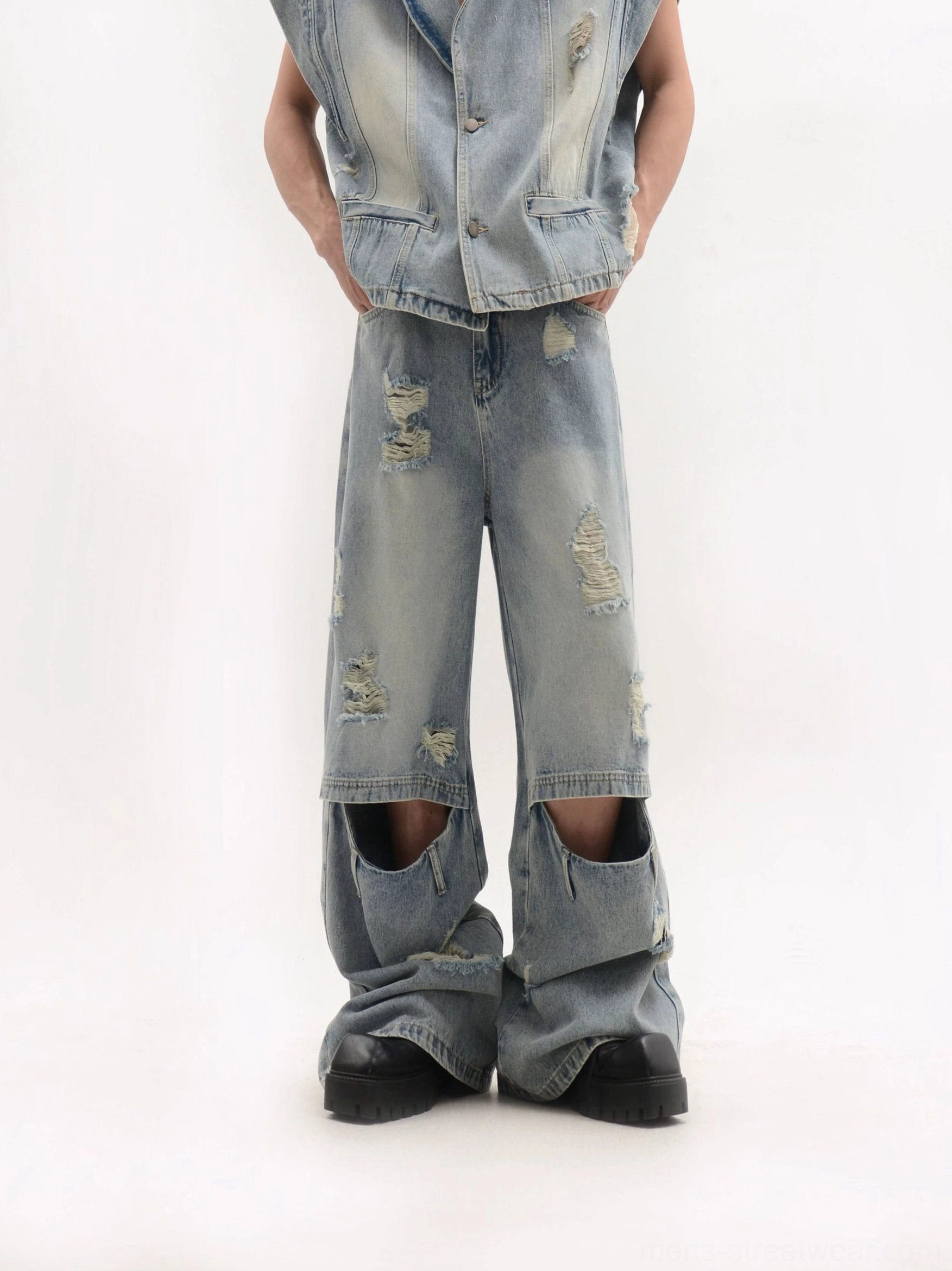 Low-angle full view of a complete oversized distressed denim vest and knee-cutout wide-leg jeans streetwear suit