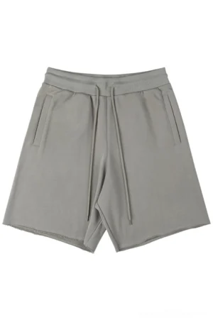 Oversized drawstring sweat shorts flat lay front view taupe grey neutral streetwear casual shorts with side pockets and raw cut hems