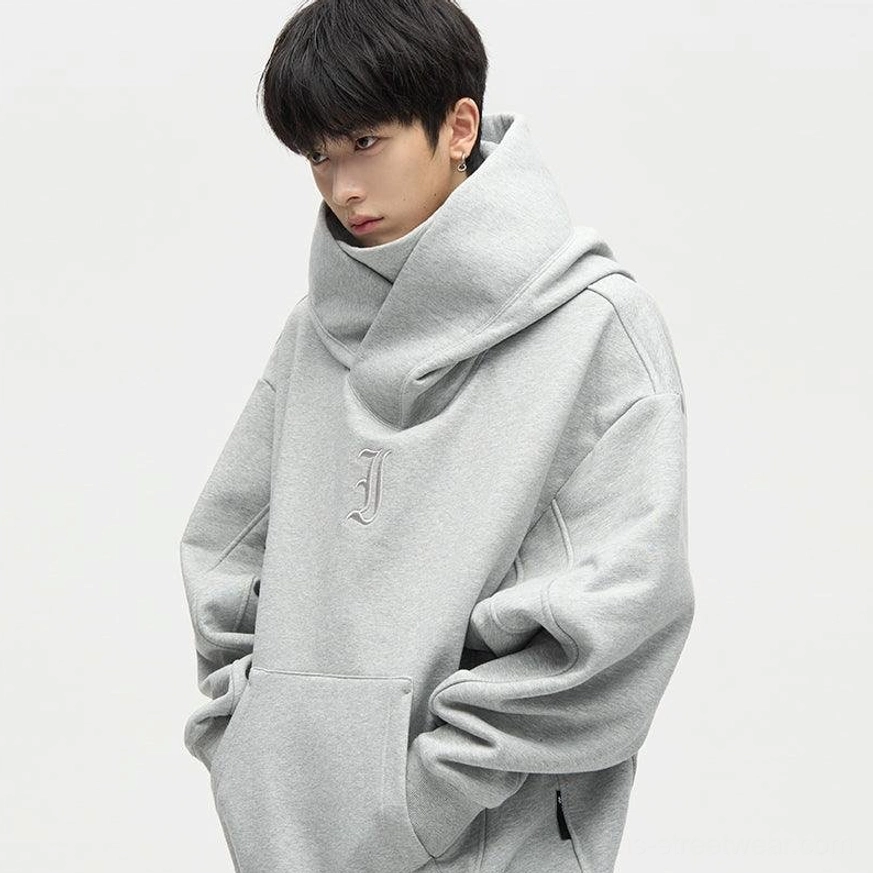 Gray oversized high-neck streetwear hoodie close-up with tonal gothic-style chest embroidery and front kangaroo pocket