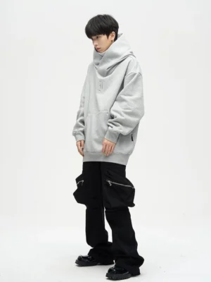 Gray oversized dual-layer high-neck hoodie styled with black cargo pants in a white studio streetwear outfit