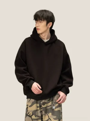 Oversized black fleece pullover hoodie with dropped shoulders ribbed cuffs and minimalist Korean streetwear silhouette