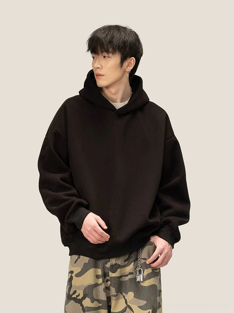 Oversized black fleece pullover hoodie with dropped shoulders ribbed cuffs and minimalist Korean streetwear silhouette