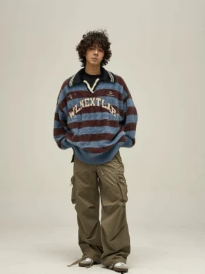 Full-body front view of a relaxed oversized fuzzy rugby sweater styled with cargo trousers, bold blue and brown stripes, and a contrast polo collar
