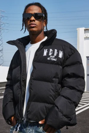 Front full-body view of a black oversized graphic puffer jacket with quilted panels, stand collar, and printed chest lettering styled for Korean streetwear