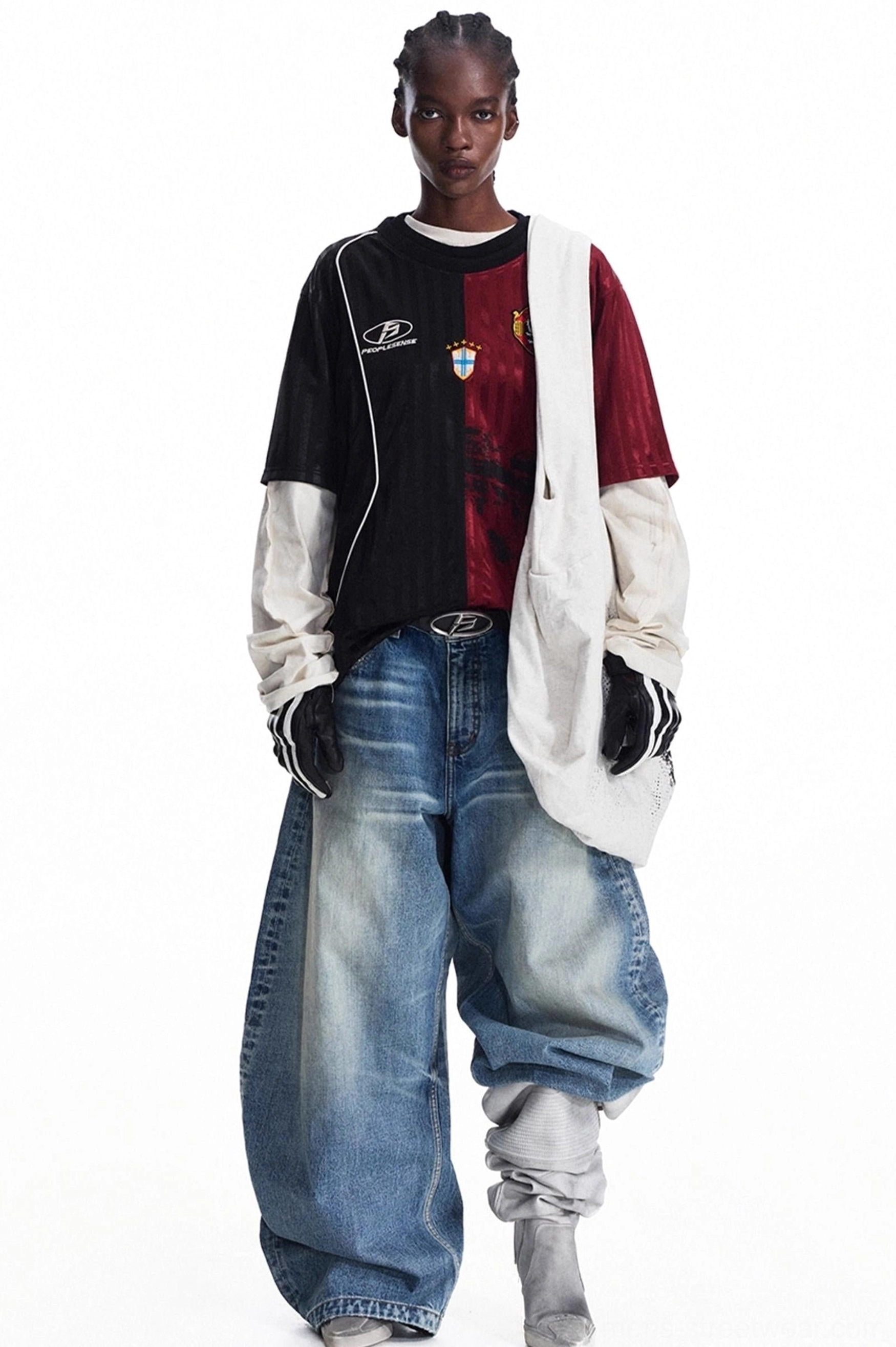 Side view of an oversized gray canvas tote bag with distressed black print styled with a black and red football jersey
