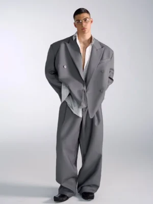 Men's oversized gray double-breasted blazer and wide-leg trousers in a full-body Seoul streetwear suit outfit