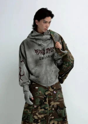Male model wearing an oversized faded grey graphic zip-up hoodie with red chest and sleeve prints in a Seoul streetwear outfit