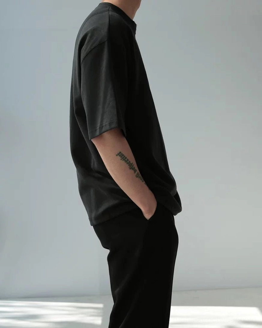 Oversized half-zip cotton tee showing boxy fit dropped shoulder construction and clean minimal design