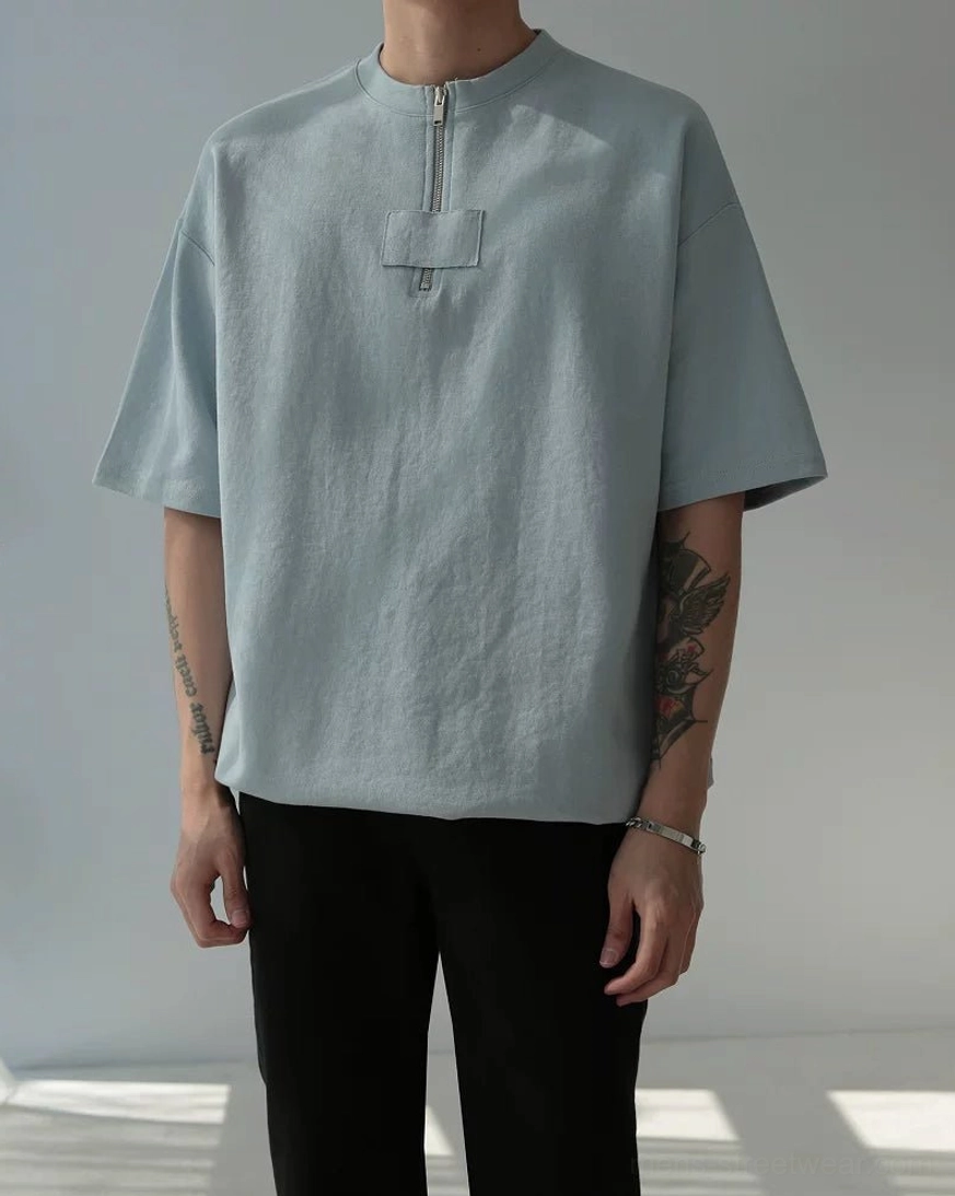 Full-body Korean streetwear outfit featuring hazy blue oversized half-zip cotton tee and black trousers