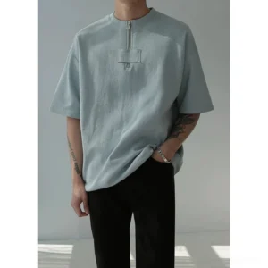 Male model wearing hazy blue oversized half-zip cotton tee with black relaxed pants in Korean streetwear outfit
