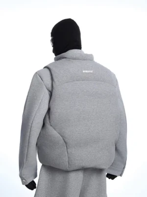 Rear three-quarter view of an oversized heather gray quilted tech fleece jacket with geometric padded panels, dropped shoulders, and matching wide-leg streetwear sweatpants