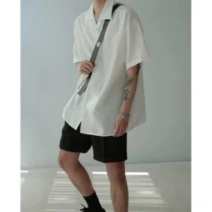 White oversized camp collar short sleeve shirt three quarter side view with black shorts and casual sneakers