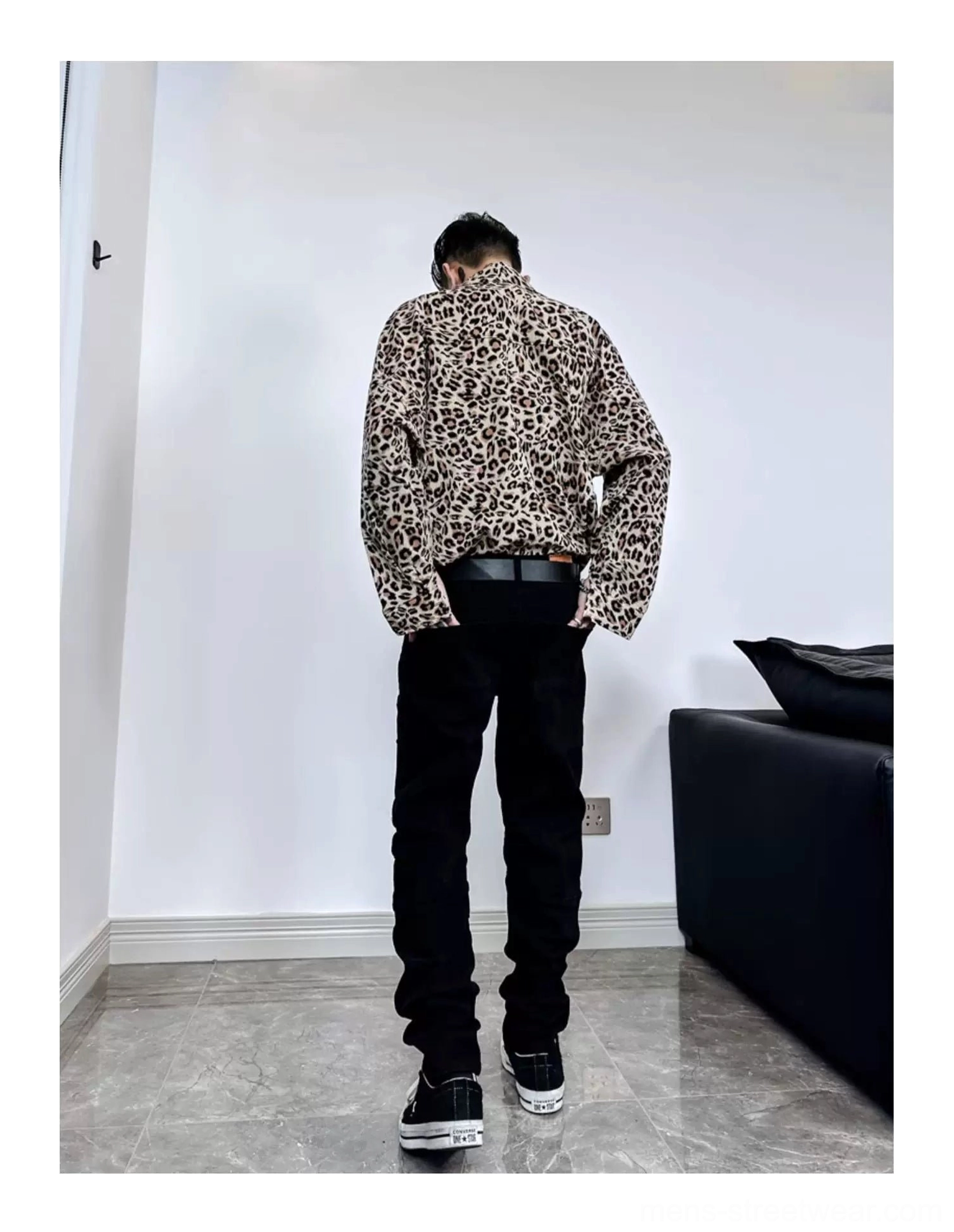 Back view showing the oversized relaxed fit and straight hem of a leopard print satin streetwear shirt styled with jeans and skate shoes